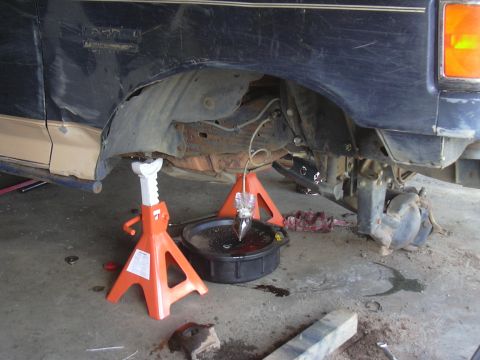 1991 Ford Bronco - Vehicle undergoing brake fluid service, showing rear axle and suspension components.