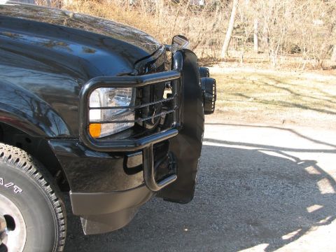 2003 Ford Excursion - Front view of a black SUV equipped with a brush guard and auxiliary lights.