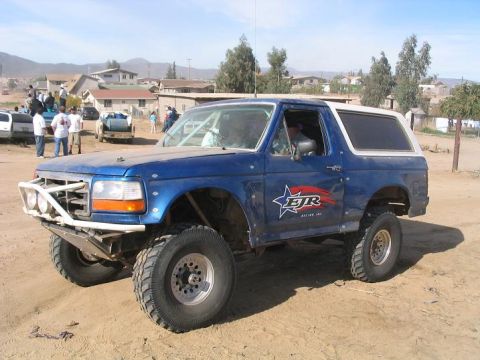 1984 Ford Bronco - This modified Bronco features off-road tires and a reinforced front bumper, suggesting it's built for terrain.