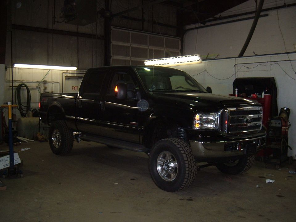 Black pickup truck with chrome grille and aftermarket light bar