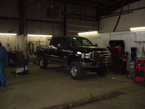 1979 Ford Bronco - A black pickup truck is parked inside a garage with tools and equipment visible.