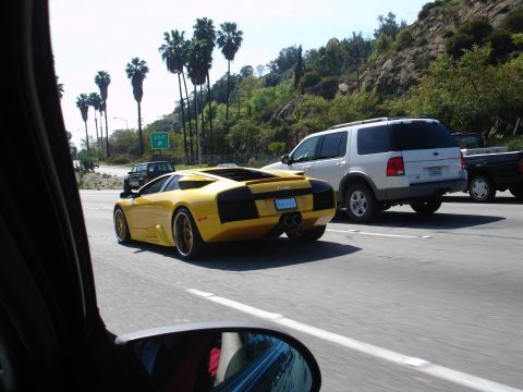 1993 Ford Taurus - A yellow Lamborghini Murciélago is seen driving on a highway, accompanied by other vehicles.