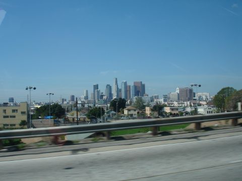 1993 Ford Taurus - A panoramic view of a city skyline, with numerous buildings of varying heights against a bright blue sky.