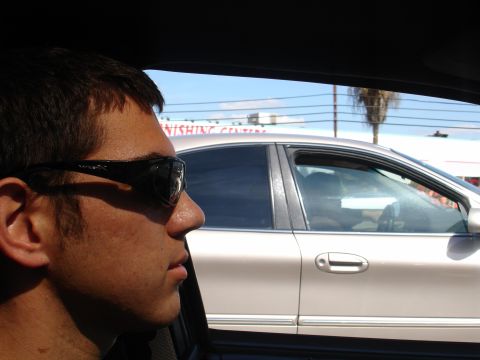 1993 Ford Taurus - Passenger in car observes another vehicle passing on a sunny day with palm trees visible.