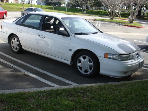 1993 Ford Taurus - This 1993 Ford Taurus sedan is parked in a lot, showing its driver's side and front quarter view.