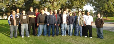 1993 Ford Taurus - A group of men pose for a photo outdoors, standing on a grassy area with trees in the background.