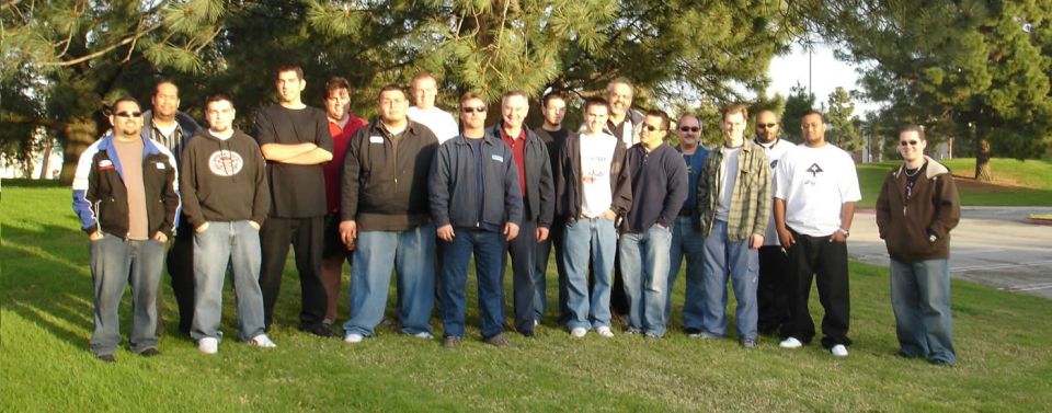 Group of men standing on grass in front of trees