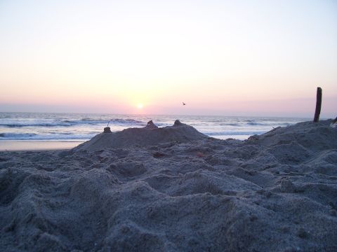 1994 Ford Probe - Sunset over the ocean with sandcastles in the foreground.