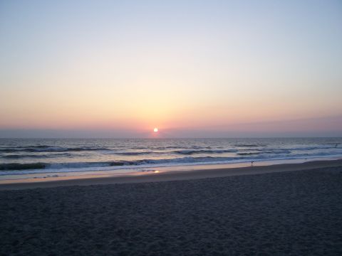 1994 Ford Probe - The sun sets over the ocean, casting soft colors across the sky and water.