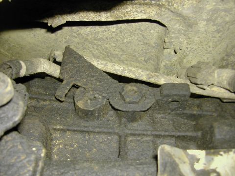1993 Ford Bronco - Close-up of a greasy metal bracket and bolts on the underside of a vehicle.