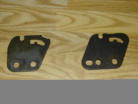 1993 Ford Bronco - Two metal brackets are shown on a wooden surface. The registry claims they are from a 1993 Ford Bronco, but this cannot be verified from th…