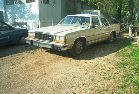 1985 Ford Crown Victoria LTD - 1985 Ford Crown Victoria LTD parked in a gravel lot with other vehicles visible.