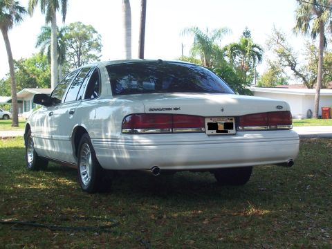 1997 Ford Crown Victoria - Rear view of a white 1997 Ford Crown Victoria sedan parked on a grassy lawn.