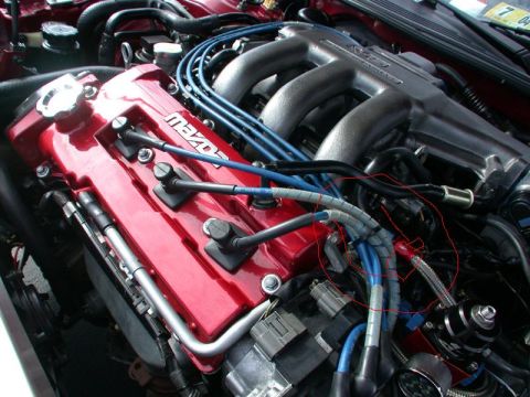 1994 Ford Probe - Close-up view of a Mazda engine, highlighting the red valve cover and blue spark plug wires.