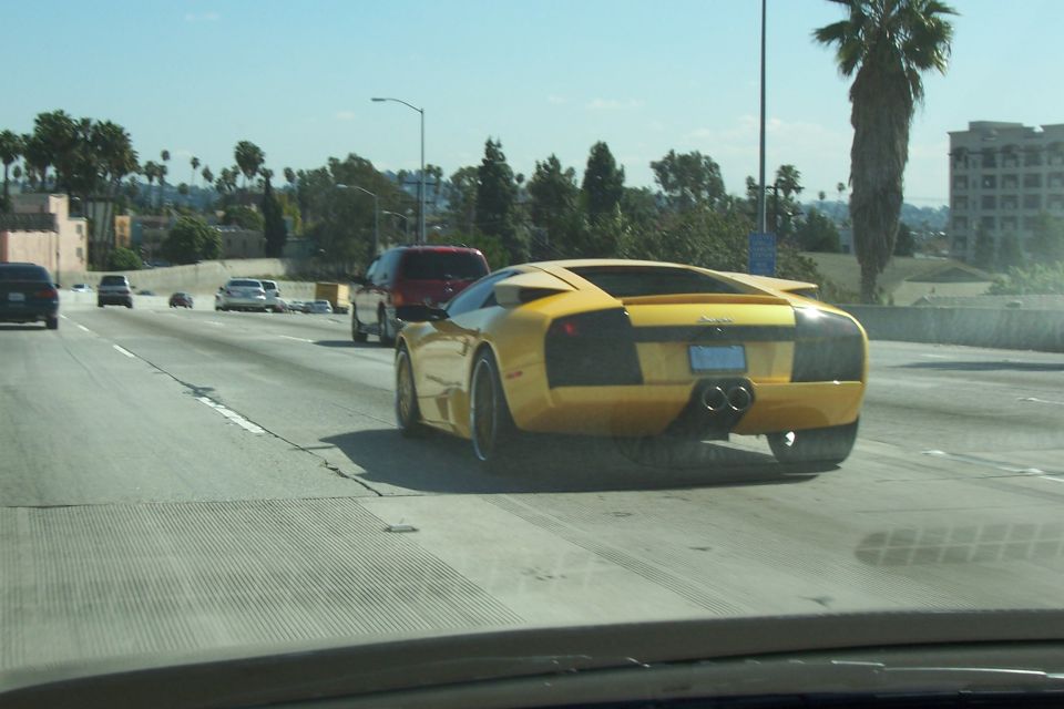 Yellow sports car rear view on highway