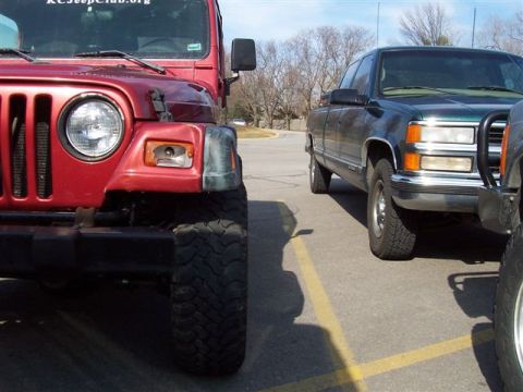 1998 Jeep TJ - Two vehicles parked side-by-side on a paved surface with yellow lines.