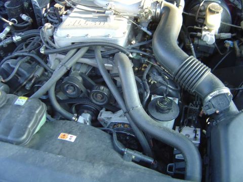 1998 Ford Crown Victoria - The engine bay of a vehicle, showing various mechanical parts and hoses.