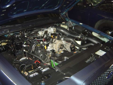 1998 Ford Crown Victoria - Engine bay of a 1998 Ford Crown Victoria, showing the V8 engine and battery.