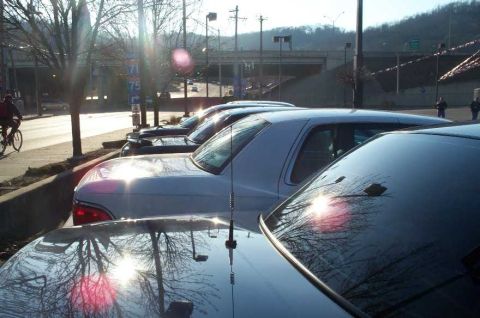 1998 Ford Crown Victoria - Several cars are parked along a street, with a silver 1998 Ford Crown Victoria prominently visible in the foreground.