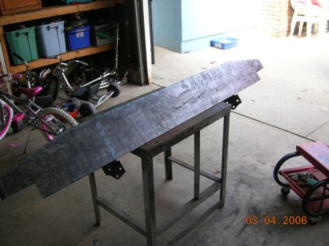 1985 Ford Bronco - Metal bumper part on a stand in a garage, with bicycles and other items in the background.