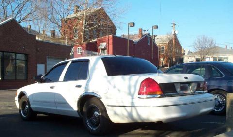 1998 Ford Crown Victoria - Rear view of a white 1998 Ford Crown Victoria parked next to another vehicle.