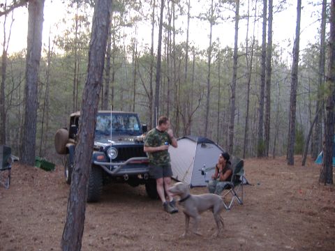 2004 Jeep Wrangler - A 2004 Jeep TJ is parked at a campsite in a wooded area with people and tents.