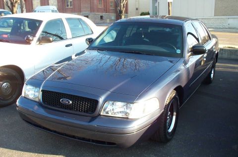 1998 Ford Crown Victoria - A dark blue 1998 Ford Crown Victoria is seen parked next to a white police car during a meet.