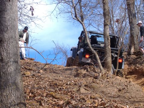 2004 Jeep Wrangler - Jeep TJ navigates an off-road trail with onlookers present.