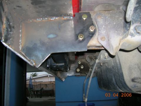 1985 Ford Bronco - Close-up view of a custom-fabricated metal bracket attached to the underside of a vehicle.