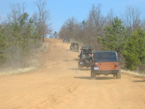 2004 Jeep Wrangler - Multiple Jeeps navigate a dirt trail during an off-road excursion.