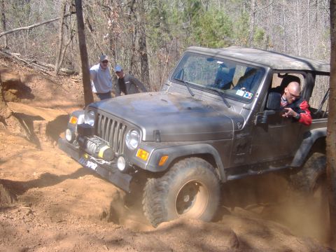 2004 Jeep Wrangler - This Jeep Wrangler navigates a challenging dirt trail, kicking up dust as it goes.