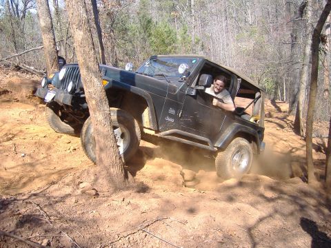 2004 Jeep Wrangler - A driver navigates a challenging off-road trail in a black Jeep Wrangler TJ.