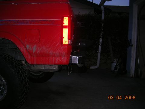 1985 Ford Bronco - The rear of a red truck is visible, showing the bumper and taillight. The photo was taken on March 4, 2006.