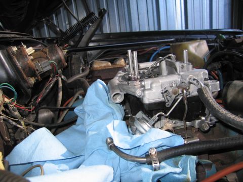 1991 Ford LTD Crown Victoria - carburetor installed on an intake in an engine bay, surrounded by wiring, hoses and a blue shop towel.