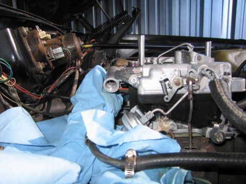 1991 Ford LTD Crown Victoria - Close view of a carburetor mounted in a vehicle engine bay, with tangled wiring and a blue shop towel nearby.