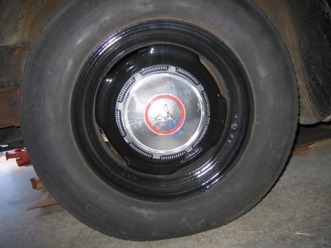 1991 Ford LTD Crown Victoria - tire mounted on a steel wheel with a chrome dog-dish hubcap featuring a red-ringed center emblem.