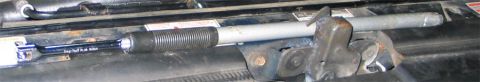 1994 Ford Bronco - A long gray steel pipe slipped over the handle of a black ratchet or breaker bar as a cheater bar for extra leverage, resting across the ra…