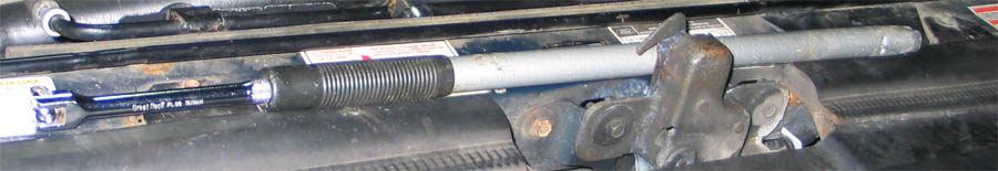 Steel cheater pipe over a breaker bar handle at the front of an engine bay