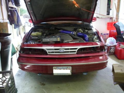 1995 Ford Crown Victoria - Front view of a 1995 Ford Crown Victoria with its hood open, revealing the engine compartment.