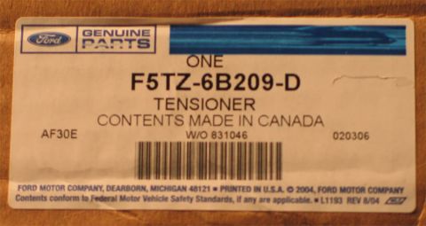 1994 Ford Bronco - Close-up of a Ford Genuine Parts box label reading 'ONE F5TZ-6B209-D TENSIONER, CONTENTS MADE IN CANADA' with a barcode, W/O 831046, and Fo…