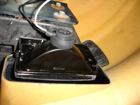 1993 Ford Taurus - Close-up of a black foglight assembly with chrome trim, showing wiring and mounting hardware.