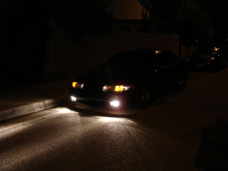 Black sedan with foglights on at night
