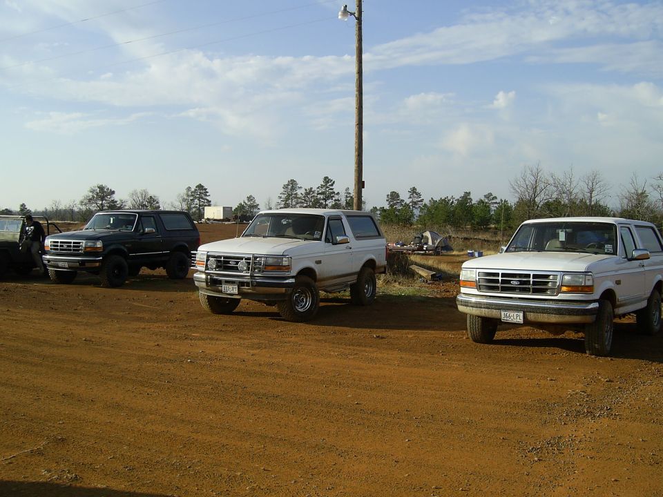 Three 1996 Ford Broncos parked on a dirt lot