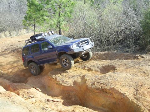 1996 Ford Bronco - This SUV is navigating a challenging off-road course with steep inclines and rough terrain.
