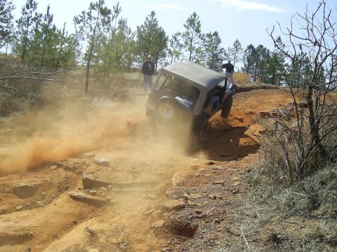 1996 Ford Bronco - An off-road vehicle navigates a dusty, rocky terrain during an event.