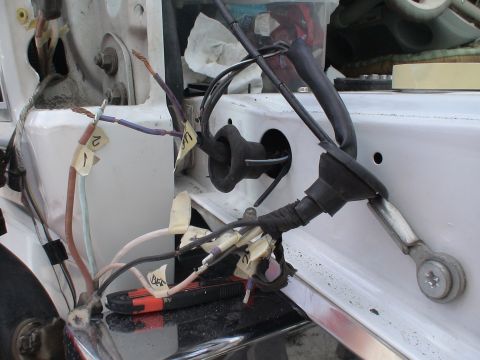 1993 Ford C-350 (Centurion Conversions) - A close-up view of a vehicle's electrical wiring, showing various wires, connectors, and a utility knife on the surface.