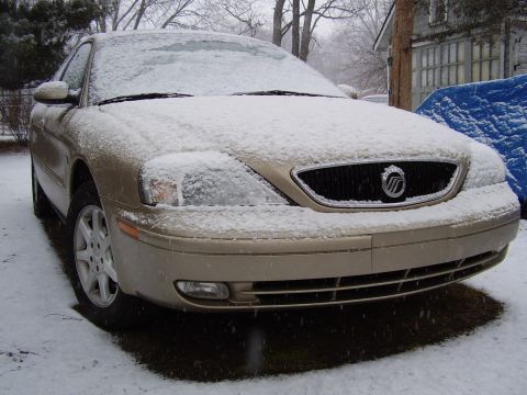 1997 Ford Taurus - This gold sedan, likely a Mercury Sable from the early 2000s, is seen parked in the snow.