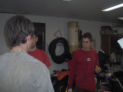 1996 Ford Probe - A group of people are gathered in a garage, with one person holding a slice of pizza.