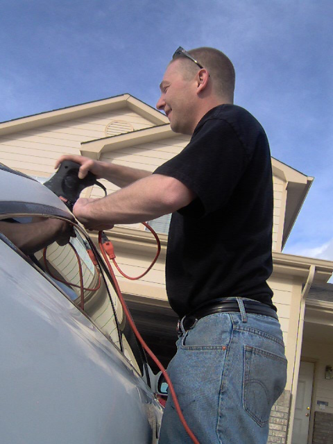 1996 Ford Probe - A man is seen charging an electric vehicle in front of a suburban home.