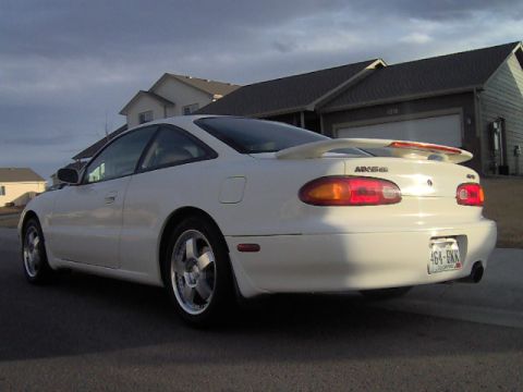 1996 Ford Probe - The rear view of a white coupe with a spoiler and distinctive taillights.